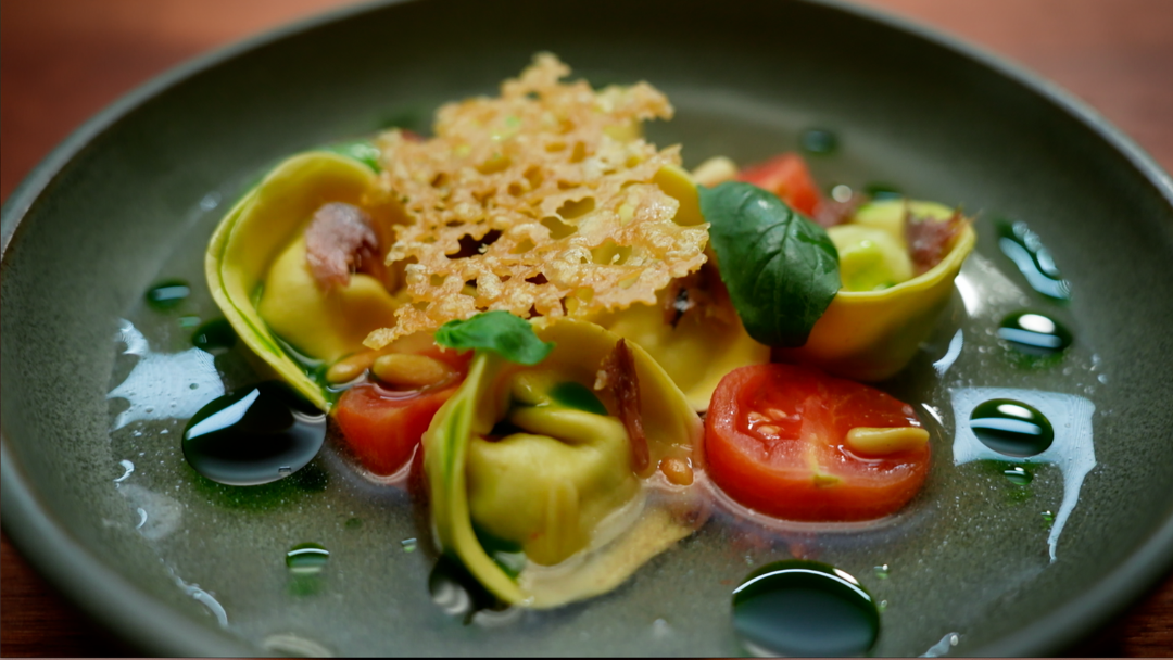 Ricotta And Cavolo Nero Tortellini With Warm Tomato Cucumber Water, Basil Oil, Anchovy, Pine Nuts And Parmesan Crisp